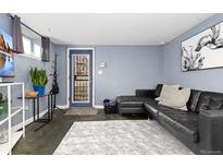 Modern living room with stylish gray walls, a black leather couch, and decor at 1310 N Corona St # A, Denver, CO 80218