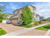 Beautiful two-story home with brick driveway, manicured lawn, and attached two car garage at 240 S Oak Hill St, Aurora, CO 80018