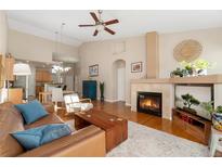 Open living room featuring a fireplace, high ceilings, and hardwood floors at 6606 S Reed Way # B, Littleton, CO 80123