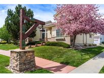 House exterior showcasing blooming tree and neighborhood entrance at 14341 Cottage Way, Broomfield, CO 80023