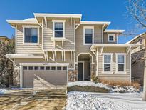 Two-story house with beige siding, stone accents, and a two-car garage at 10767 Mountshire Cir, Highlands Ranch, CO 80126