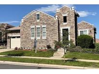 Charming stone home with a manicured lawn and a well-maintained landscape in a suburban neighborhood at 12121 Bryant St, Westminster, CO 80234
