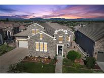 Beautiful stone home features a landscaped yard and a mountain view at sunset at 12121 Bryant St, Westminster, CO 80234