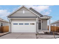Charming single-Gathering home features a two-car garage, neutral paint, and well-maintained landscaping at 9465 Yampa St, Commerce City, CO 80022