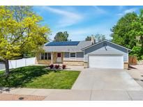 Charming single-story home featuring solar panels, a well-manicured lawn, and an attached two-car garage at 1606 S Flanders Way, Aurora, CO 80017