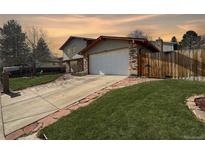 Two-story home featuring brick accents, attached two-car garage and mature landscaping at 85 Yank Way, Lakewood, CO 80228