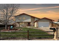 Charming two-story home featuring brick accents, mature landscaping, and an attached two car garage at 85 Yank Way, Lakewood, CO 80228