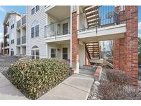 Exterior view of a multi-story building with brick accents, balconies, and well-maintained landscaping at 1629 S Deframe St # A1, Lakewood, CO 80228