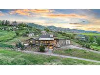 Stunning two-story home nestled in a hillside setting with mountain views and attached two car garage at 12947 Lazy Dog Ln, Littleton, CO 80127