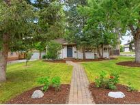 Charming single story home with a brick walkway, lush lawn and mature trees at 2680 S Garfield Cir, Denver, CO 80210