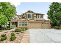 Charming two-story home with three-car garage, stone accents, and beautifully landscaped front yard at 15348 W 75Th Pl, Arvada, CO 80007