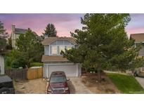 Charming two-story home featuring a well-manicured lawn, mature trees, and a two-car garage in a quiet neighborhood at 613 N Brentwood Ct, Castle Rock, CO 80104