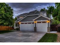 Charming two-story home with a gray exterior, a two-car garage, and a well-manicured lawn at 6358 S Miller Way, Littleton, CO 80127