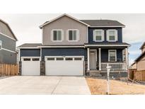 Charming two-story home featuring a three-car garage, stone accents, and a welcoming front porch at 13921 Scarlet Sage Ln, Parker, CO 80134