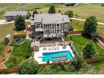 Stunning aerial view of home with pool, deck, and spacious backyard, perfect for outdoor living at 8682 N Sundown Trl, Parker, CO 80134
