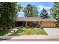 Charming brick home featuring a well-maintained lawn and mature trees in a tranquil neighborhood at 7577 S Pierce Way, Littleton, CO 80128