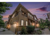 Inviting two-story townhome features a balcony, a garage, and mature landscaping at 10127 Bluffmont Ln, Lone Tree, CO 80124