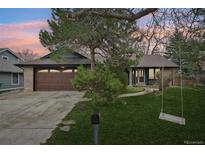 Charming single-Gathering home with lush front yard, mature trees, swing and brick and siding exterior at 2026 S Pitkin St, Aurora, CO 80013