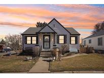 Charming home featuring meticulous landscaping and an inviting walkway during a colorful sunset at 3700 S Sherman St, Englewood, CO 80113