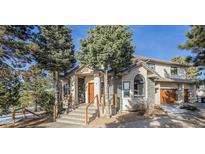 Charming two-story home with stone accents, mature trees, and inviting front entrance at 17870 New London Rd, Monument, CO 80132