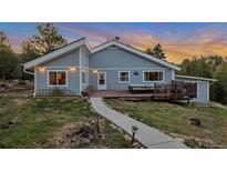 Charming single-story home boasts a spacious deck and inviting outdoor dining area, perfect for enjoying scenic views at 11348 Ranch Elsie Rd, Golden, CO 80403