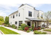 Modern two-story home with white siding, black windows, and covered front porch with landscaped yard at 801 8Th St, Golden, CO 80401