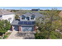 Charming two-story home with a gray roof, brick accents, solar panels, and a two-car garage at 9567 W 107Th Dr, Broomfield, CO 80021