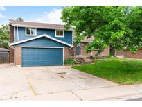 Charming two-story home with a blue exterior, brick accents, an attached garage, and a well-maintained front yard at 544 S Victor Way, Aurora, CO 80012