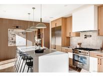 Modern kitchen with stainless steel appliances, wood cabinets, large island and hardwood floors at 2471 Quitman St, Denver, CO 80212