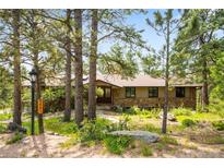 Charming single-story home with stone accents, mature trees, and inviting curb appeal at 2907 Hiwan Dr, Evergreen, CO 80439