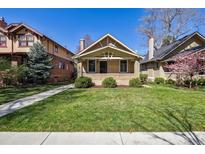 Charming bungalow featuring a brick facade, well-maintained lawn, and inviting front porch at 1111 S Corona St, Denver, CO 80210