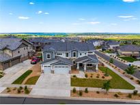Beautiful two-story home featuring a three-car garage, well-manicured lawn, professional landscaping, and a picturesque view at 9566 Poppy Way, Arvada, CO 80007