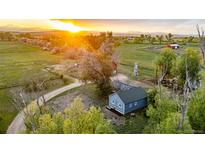 Aerial view of the property featuring various outbuildings, silos, and green pastures at 13183 N 95Th St, Longmont, CO 80504