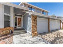 A charming home featuring a brick-accented garage and inviting front entrance with steps and a security door at 4022 S Kalispell St, Aurora, CO 80013