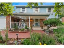 Charming two-story home with a brick facade, a welcoming front porch and professionally landscaped yard at 3765 E Easter Dr, Centennial, CO 80122