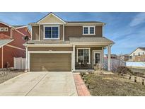 Beautiful two-story home with a well-manicured lawn, attached garage, and inviting front porch at 5541 Killarney Ct, Denver, CO 80249