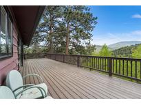 Spacious deck with wooden railing, offering stunning views of the surrounding landscape at 32171 Lodgepole Dr, Evergreen, CO 80439