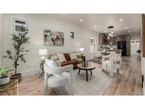 Inviting living room featuring hardwood floors, stylish furniture, and an open layout leading to the kitchen at 1439 S Sherman St, Denver, CO 80210