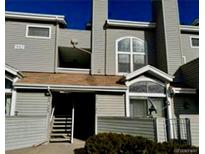 View of the townhome exterior with a stairway leading to the front door and a balcony on the second floor at 942 S Walden St # 206, Aurora, CO 80017