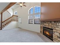 Bright living room with vaulted ceilings, stone fireplace, and large windows at 942 S Walden St # 206, Aurora, CO 80017