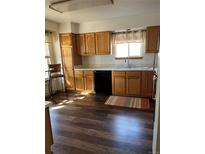 Well-lit kitchen with wooden cabinets, black appliances, and wood-style flooring at 9724 W Euclid Dr, Littleton, CO 80123