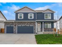 Charming two-story home featuring a three-car garage, stone accents and a well-manicured lawn at 13477 Valentia St, Thornton, CO 80602