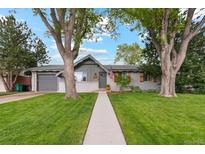 Charming single-story home with a manicured lawn, mature trees, and a welcoming walkway at 806 S Jersey St, Denver, CO 80224