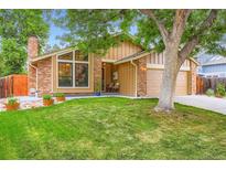 Charming brick home featuring a well-manicured lawn, brick accents, and a cozy front porch at 8845 W 81St Dr, Arvada, CO 80005