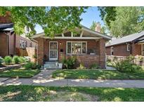 Charming brick home featuring a well-manicured lawn and inviting front porch area at 3437 W 35Th Ave, Denver, CO 80211