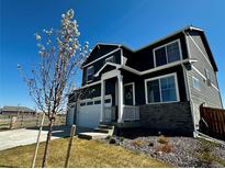 Charming two-story home featuring gray siding and a well-manicured front yard with an attached two car garage at 1800 Vantage Pkwy, Berthoud, CO 80513