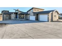 Stunning contemporary home featuring an expansive driveway and two-car garage at 19647 Guildford Ct, Monument, CO 80132