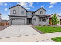 Modern two-story home with gray siding, attached garages, and well-maintained lawn at 1825 Morgan Dr, Erie, CO 80516