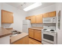 Bright kitchen features wood cabinets, white appliances, and lots of counter space at 444 17Th St # 802, Denver, CO 80202