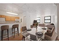Open-concept living space featuring modern furnishings, sleek kitchen, and ample natural light from the large windows at 444 17Th St # 802, Denver, CO 80202